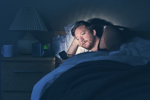 male using smartphone in bed at night